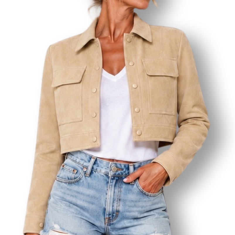 A woman modeling a cropped beige jacket over a white top and light blue denim shorts, standing against a plain white background.