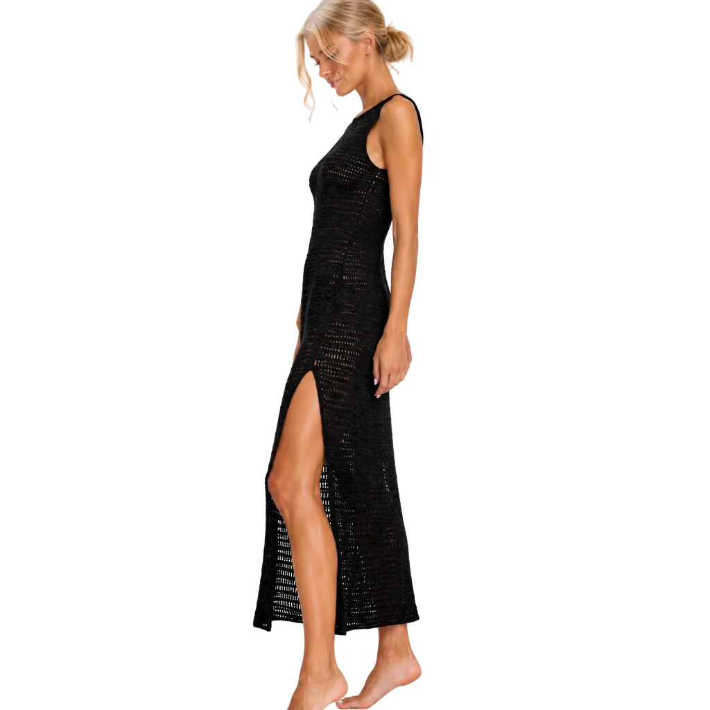 Model in side profile wearing The Split Midi, a black open-knit midi dress with a high side slit, against white.