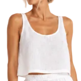 Model wearing the white Linen Travel Top by Hostess the label, with a scoop neckline, shoulder straps and cropped hem, styled with white shorts.