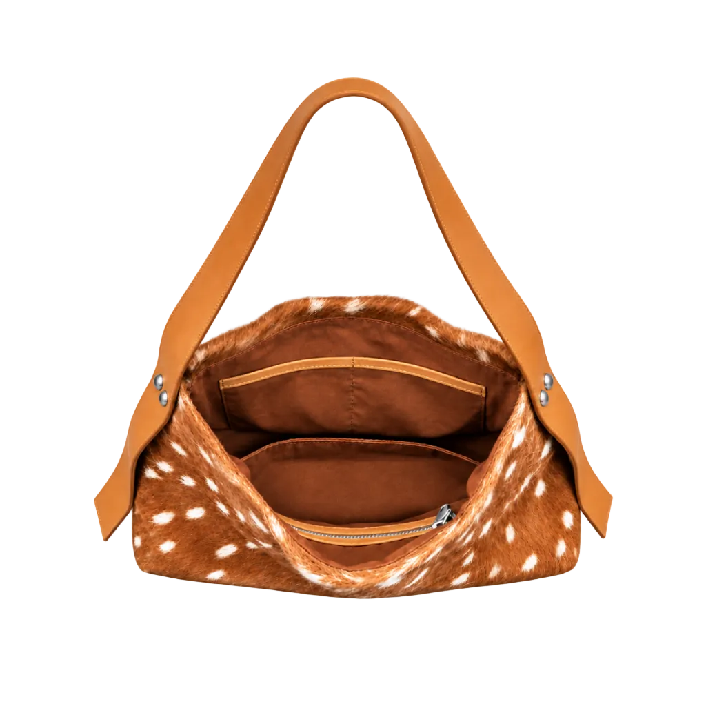 Open interior of The Deer Carry-On shoulder bag by Hostess the label, showing the brown lining, internal pockets, zip pocket and tan leather shoulder strap.